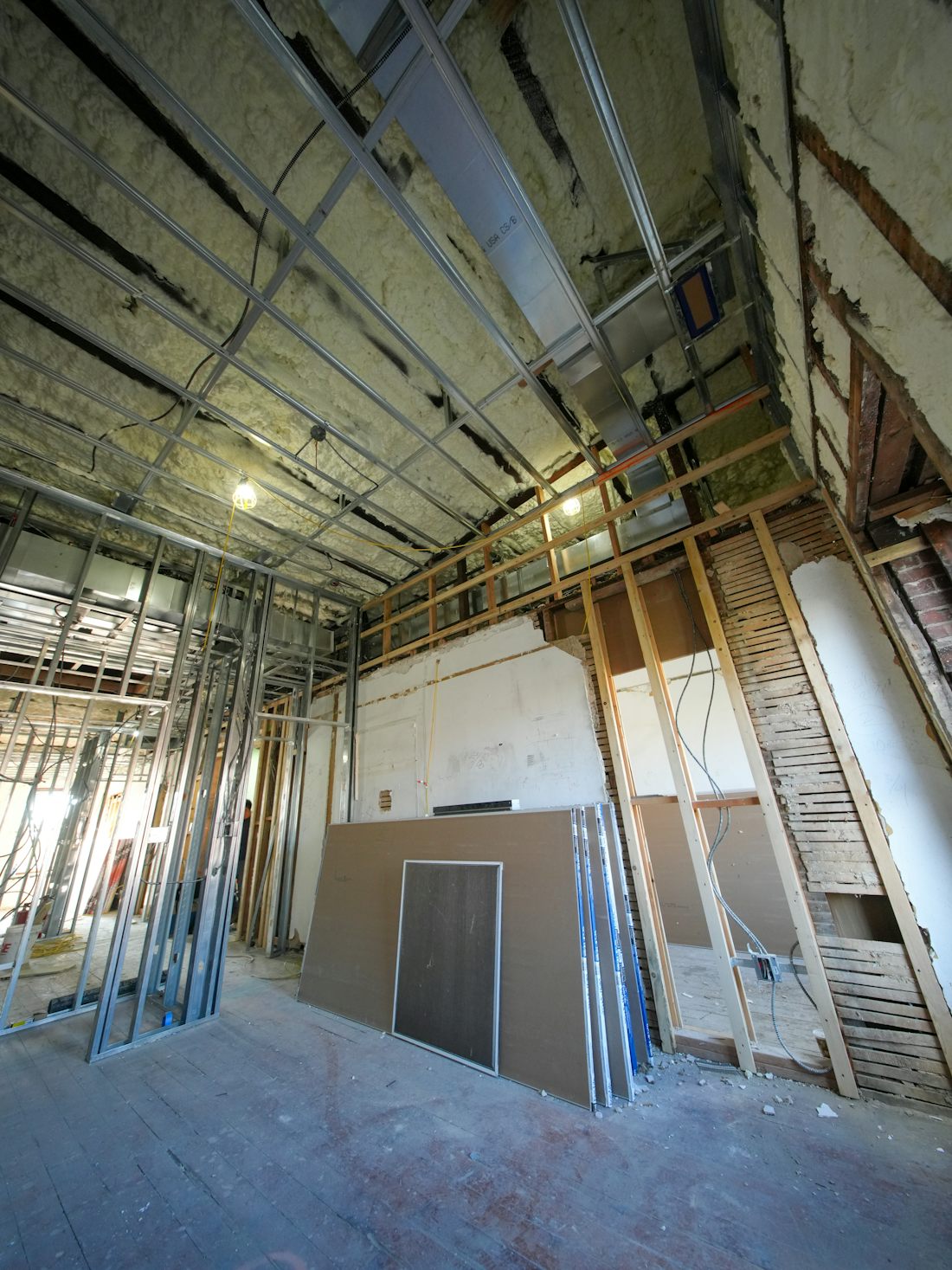 Metal stud framing and drywall sheets in a room